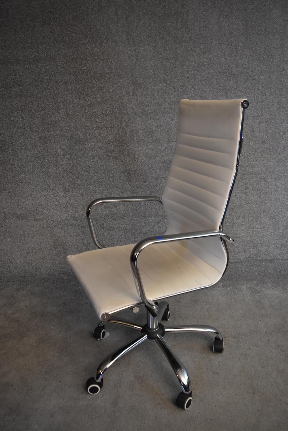 A Charles Eames style swivel office armchair in cream vinyl upholstery. H.110x56cm - Image 2 of 5