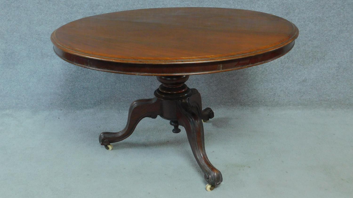 A Victorian mahogany circular dining table with tilt top action raised on carved tripod supports. - Image 2 of 7