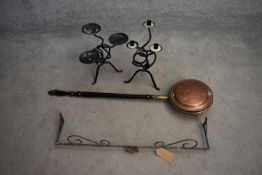 A 19th century copper warming pan, a wrought iron pelmet and two metal candlesticks. L.85cm