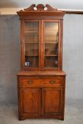 A late Victorian walnut library bookcase with glazed doors above fitted secretaire section and a