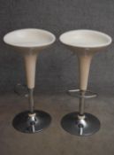 A pair of moulded adjustable high stools on chrome platform bases. H.87cm