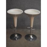 A pair of moulded adjustable high stools on chrome platform bases. H.87cm