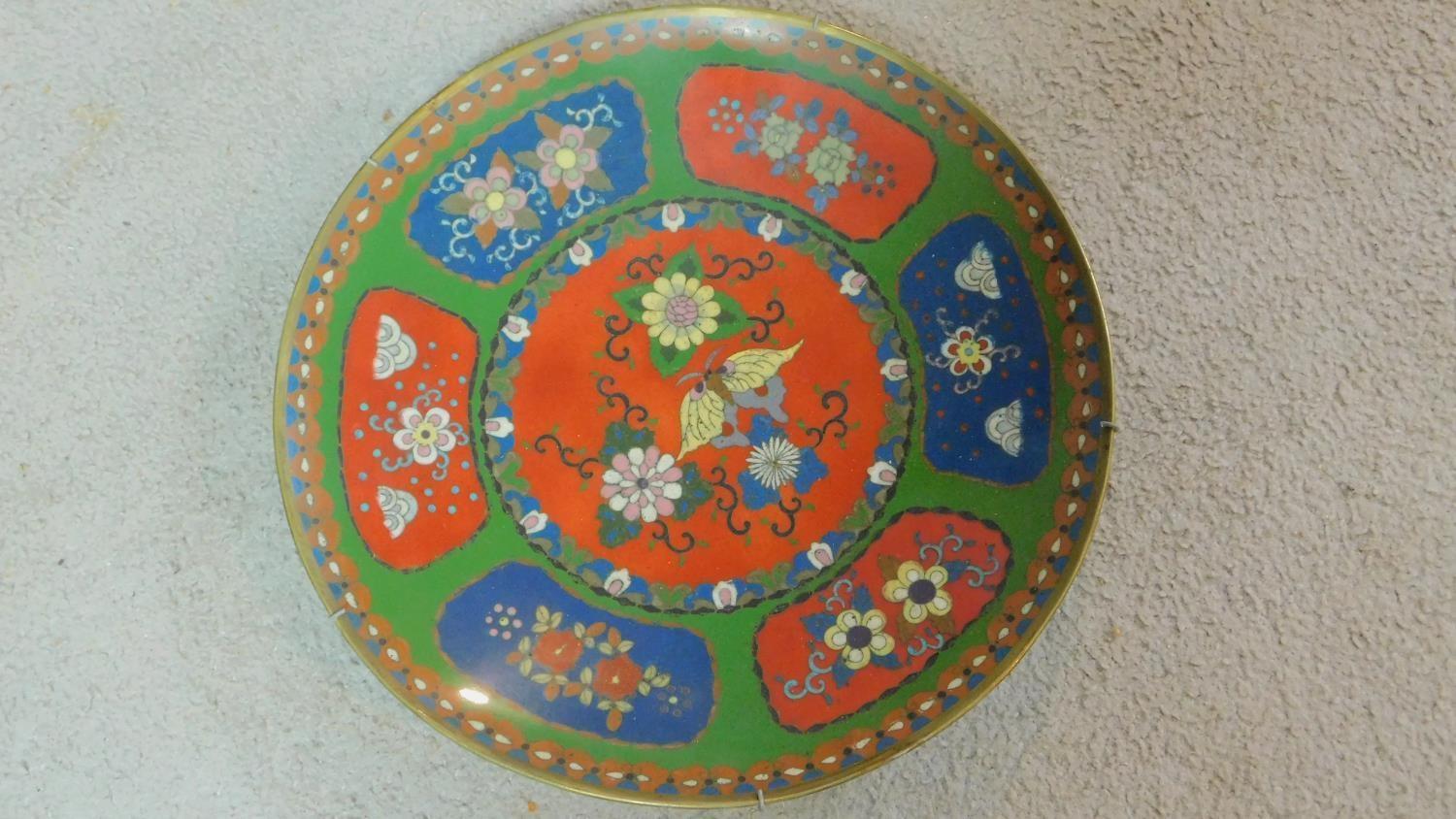 A Meji period Cloisonné enamel plate with red and blue panels on a green background decorated with - Image 2 of 5