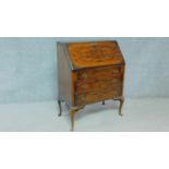 A Georgian style figured walnut bureau with fall front revealing fitted interior above three