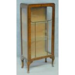 A mid 20th century Art Deco style walnut display cabinet with glazed panel door enclosing glass