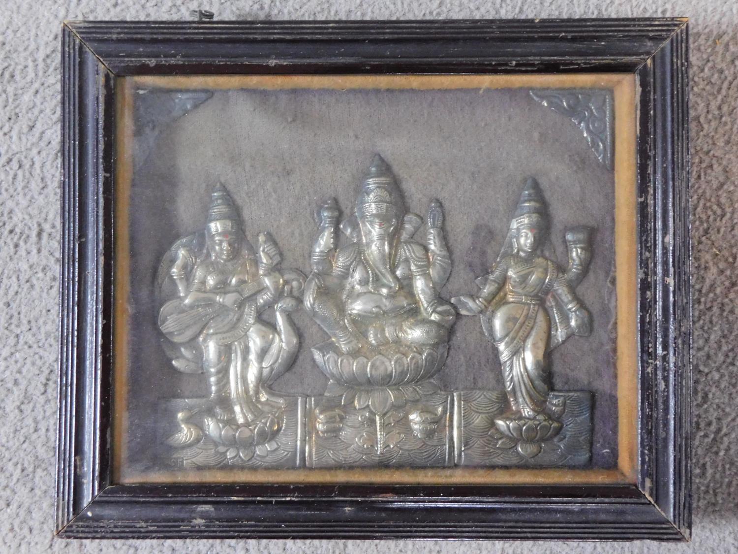 An antique framed and glazed engraved relief picture of Indian deities in white metal. Stamped to