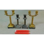 A pair of antique column form gilded brass candelabras on onyx bases with four feet along with a