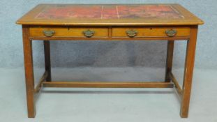 A late 19th century oak writing table with inset tooled red leather top above two frieze drawers