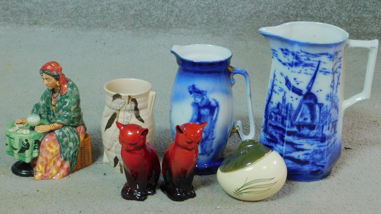 A miscellaneous collection of ceramic items. Including a pair of Royal Doulton flambe glaze seated