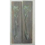 A pair of antique wooden plaques with intricately detailed relief metal floral sprigs applied.