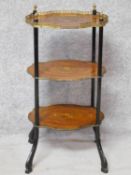 A late 19th century French style walnut and kingwood three tier etagere with central floral inlay to