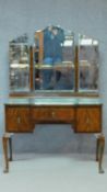 A mid 20th century figured walnut dressing table with short frieze drawer flanked by two large