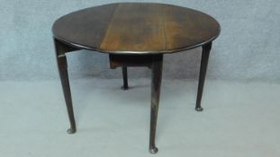 A Georgian mahogany drop flap dining table on gateleg base with cabriole supports terminating in pad