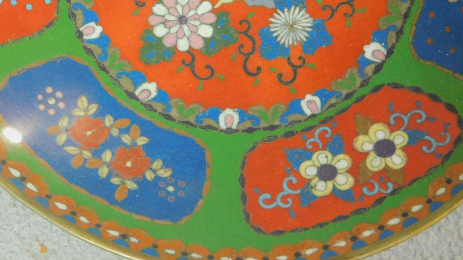 A Meji period Cloisonné enamel plate with red and blue panels on a green background decorated with - Image 4 of 5