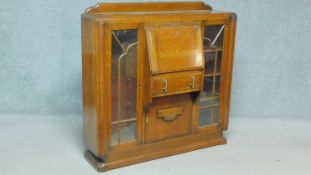 A mid 20th century Art Deco style oak bookcase with central bureau section flanked by astragal