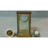 An antique brass clock movement with gilded enamel design dial with its chamfered glass and brass