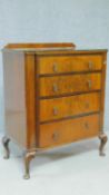 A mid 20th century figured walnut chest of four graduating drawers on cabriole supports. H.108 W.