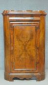 A 19th century Continental figured walnut floor standing corner cabinet with frieze drawer above