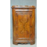A 19th century Continental figured walnut floor standing corner cabinet with frieze drawer above
