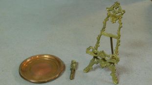 An antique brass easel with foliate design along with three engraved copper trays with dragooned