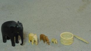A collection of antique ivory and carved items. Including an ebony elephant with carved detaling,