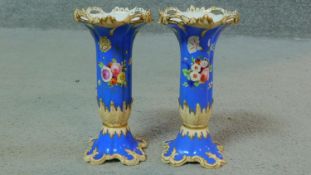 A pair of 19th century hand painted and gilded porcelain candle holders with floral design and