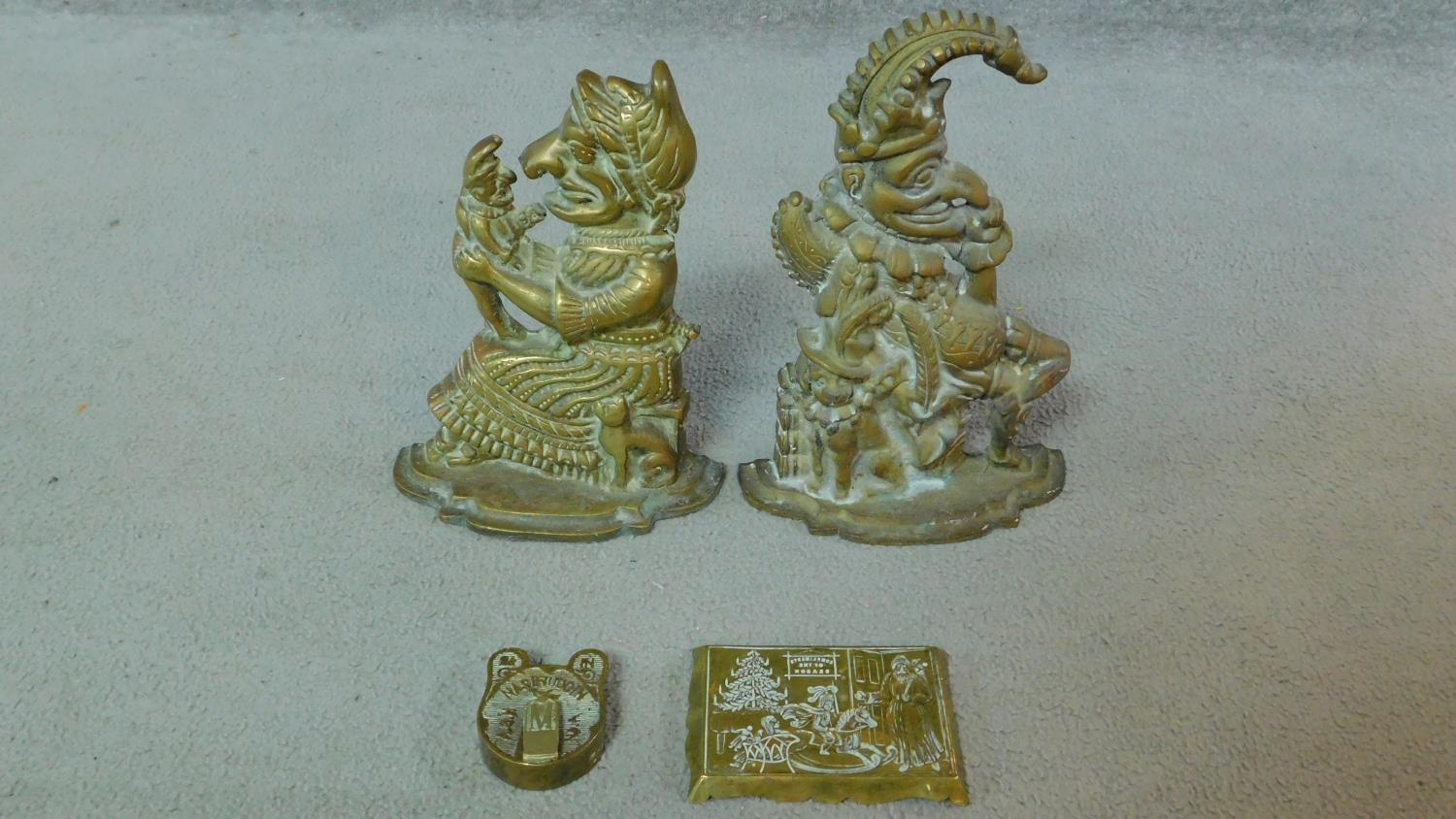 A pair of Victorian Punch and Judy brass door stops along with a repousse brass Christmas scene