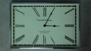 A rectangular battery powered polished stainless steel framed clock with cream face and black