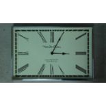 A rectangular battery powered polished stainless steel framed clock with cream face and black