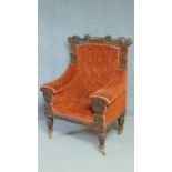 A large Regency mahogany carved throne chair in floral buttoned rouge upholstery on reeded tapering