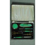 An Art Deco gilded brass green and blue engine turned enamel vanity set in a gilded blue leather