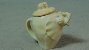 A carved vintage soapstone elephant teapot with baby elephant form finial. H.18cm