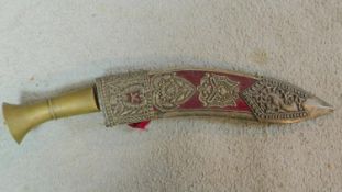 A vintage presentation Kukri knife in a pierced and engraved white metal scabbard decorated with a