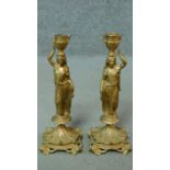 A pair of gilt metal candlesticks in the form of classical maidens carrying urns. H.28cm