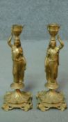 A pair of gilt metal candlesticks in the form of classical maidens carrying urns. H.28cm