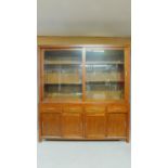 A large Eastern teak library bookcase with glazed sliding doors to the upper section above base