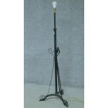 A cast iron scrolling form wrought iron tripod standard lamp. H.150cm