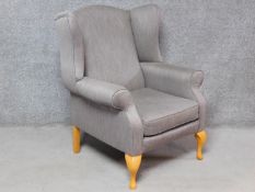 A Georgian style wing back armchair upholstered in pale grey velour on cabriole supports. H.108cm