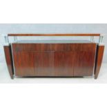 A contemporary teak and metal bound console cabinet fitted with drawers and cupboards to the base.