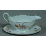 A Hutschenreuther, LHS porcelain gravy boat on stand with hand painted floral design. Makers stamp