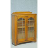 A mid 20th century oak bookcase with glazed doors enclosing shelves on bracket feet. H.99 W.79 D.