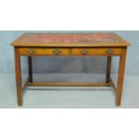 A late 19th century oak writing table with inset tooled red leather top above two frieze drawers
