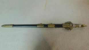 A Middle Eastern decorative sword with brass detailing and black scabbard. W.91cm