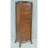 An Eastern teak narrow chest of nine drawers on splay supports. H.122 W.41 D.32cm