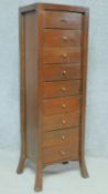 An Eastern teak narrow chest of nine drawers on splay supports. H.122 W.41 D.32cm