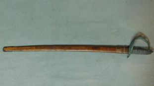 An antique cavalry sword with leather scabbard and pierced and engraved pattern scroll hilt. W.100cm