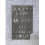An antique brass and enamel advertising sign. The white enamel letters read 'GUILLAUME & SONS,