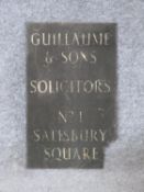 An antique brass and enamel advertising sign. The white enamel letters read 'GUILLAUME & SONS,