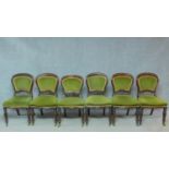 A set of six Victorian mahogany dining chairs in green velour upholstery raised on turned tapering