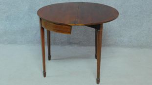 An Georgian mahogany and satinwood inlaid demi lune foldover top tea table on square tapering